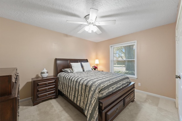 bedroom with light colored carpet, a textured ceiling, and baseboards