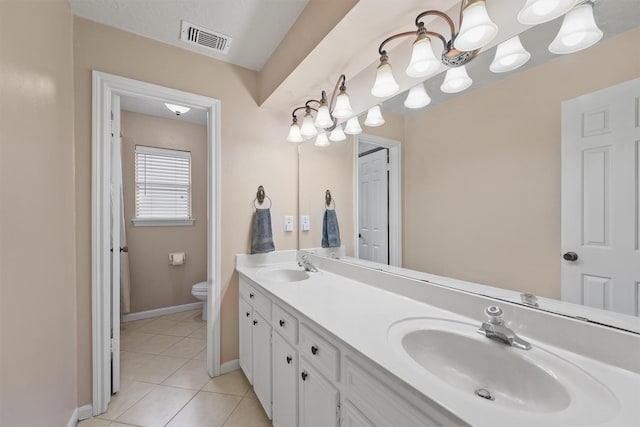 bathroom featuring toilet, a sink, visible vents, tile patterned floors, and double vanity