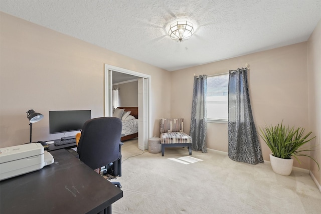 carpeted office with baseboards and a textured ceiling