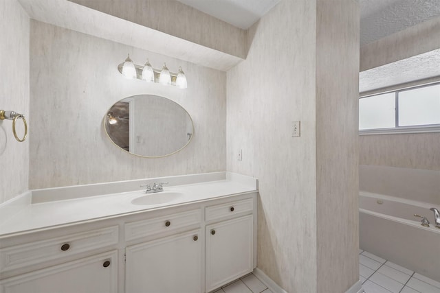 bathroom with a tub to relax in, vanity, and tile patterned floors