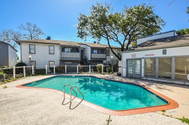 pool with a patio and fence