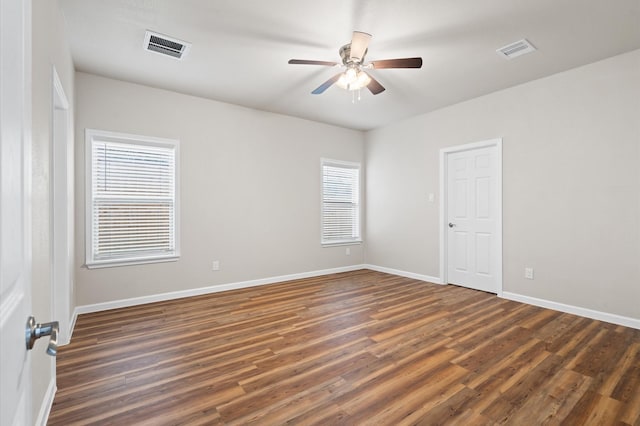 spare room with a ceiling fan, baseboards, visible vents, and wood finished floors