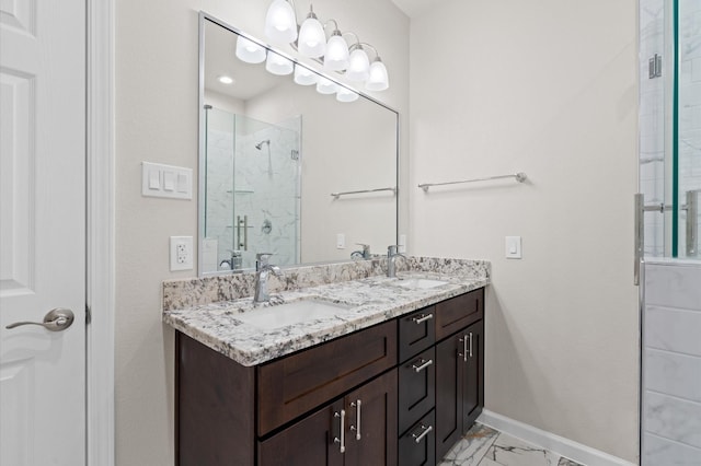 full bathroom with double vanity, marble finish floor, a sink, and a stall shower