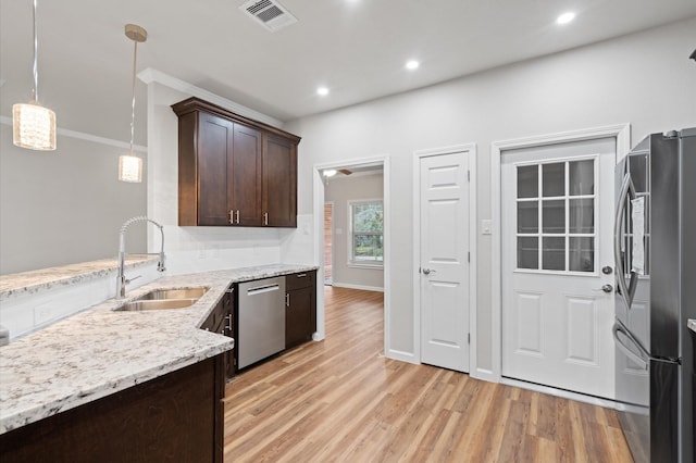 kitchen featuring dark brown cabinetry, stainless steel appliances, a sink, visible vents, and light wood finished floors