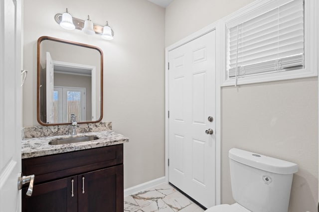 bathroom with marble finish floor, baseboards, vanity, and toilet