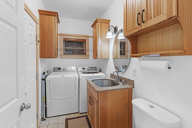 laundry room with washing machine and dryer, a sink, and light tile patterned floors