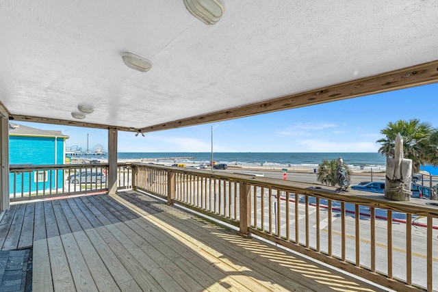 wooden terrace with a view of the beach and a water view