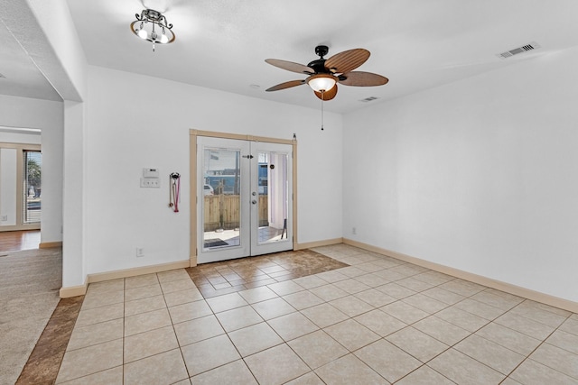 unfurnished room with french doors, light tile patterned floors, visible vents, ceiling fan, and baseboards