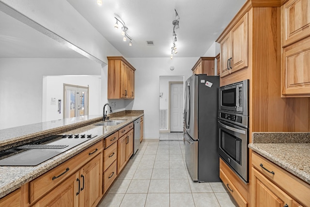 kitchen featuring light stone counters, visible vents, appliances with stainless steel finishes, light tile patterned flooring, and a sink