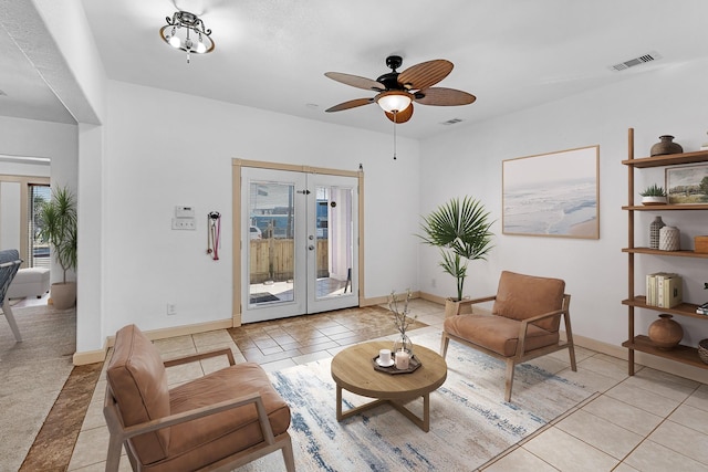 living area featuring light tile patterned floors, visible vents, and french doors