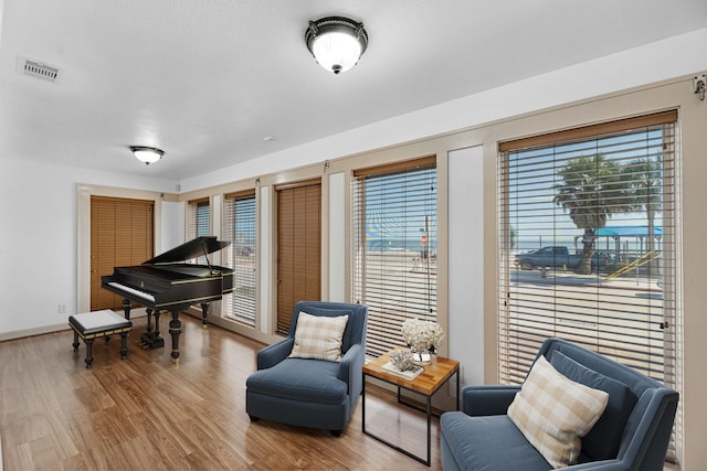 sitting room featuring a wealth of natural light, wood finished floors, visible vents, and baseboards