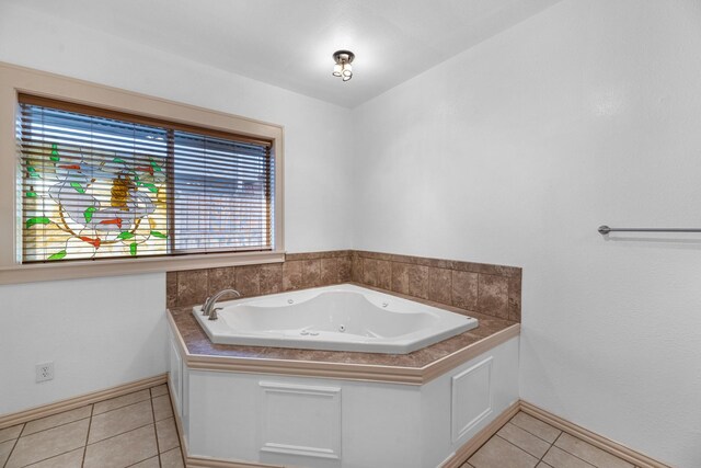 full bath with tile patterned flooring, a tub with jets, and baseboards