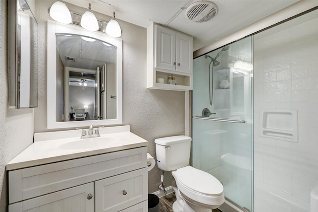 bathroom featuring a stall shower, visible vents, a textured wall, and vanity