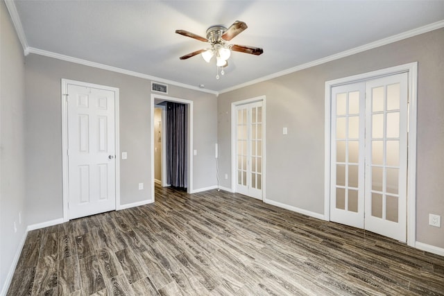 unfurnished room featuring ornamental molding, wood finished floors, visible vents, and baseboards