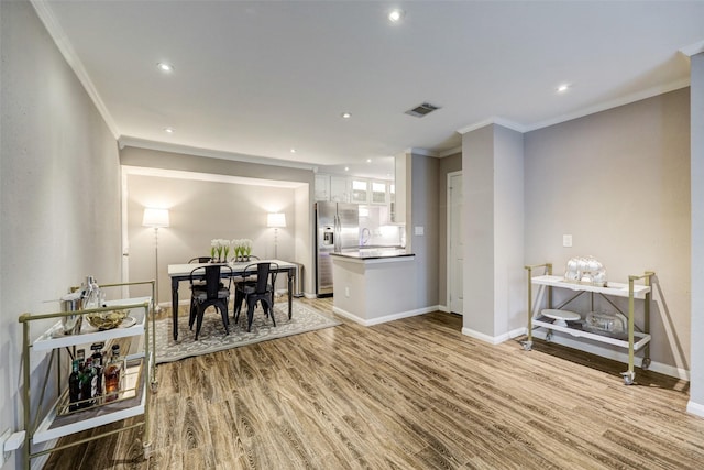 dining space with baseboards, visible vents, ornamental molding, wood finished floors, and recessed lighting