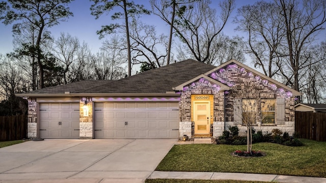 view of front of house with driveway, stone siding, an attached garage, and fence