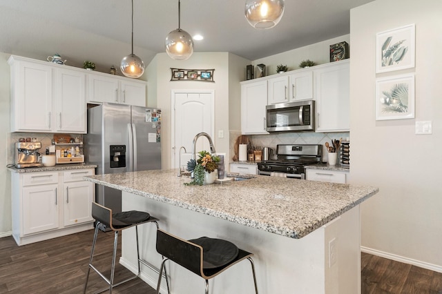 kitchen featuring dark wood-style floors, tasteful backsplash, appliances with stainless steel finishes, and a sink