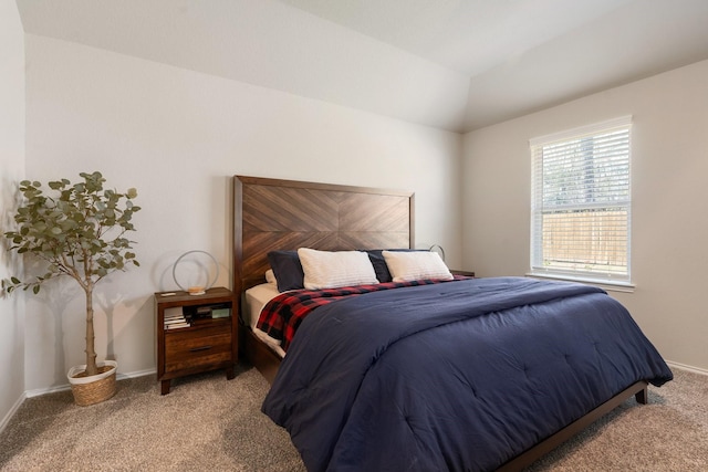 carpeted bedroom with vaulted ceiling and baseboards