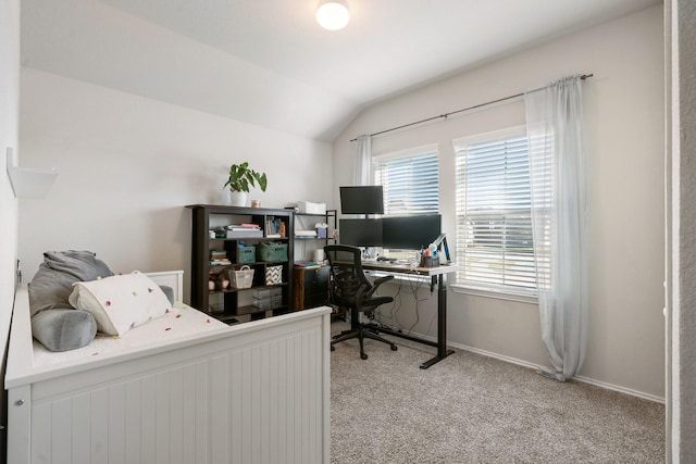 carpeted office space featuring vaulted ceiling and baseboards