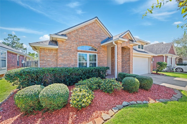 view of front facade with brick siding, concrete driveway, and a garage