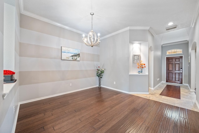 unfurnished dining area with baseboards, arched walkways, wood-type flooring, and ornamental molding