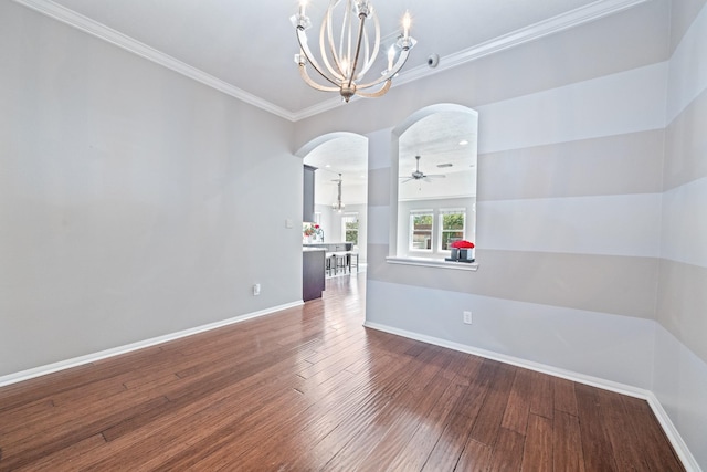 unfurnished room featuring ornamental molding, ceiling fan with notable chandelier, wood-type flooring, arched walkways, and baseboards