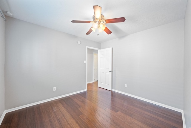 unfurnished room featuring a ceiling fan, dark wood-style floors, and baseboards