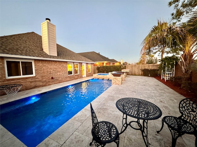 view of swimming pool featuring an in ground hot tub, a fenced backyard, a fenced in pool, and a patio area