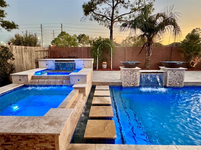 view of pool with a fenced in pool, an in ground hot tub, and a fenced backyard