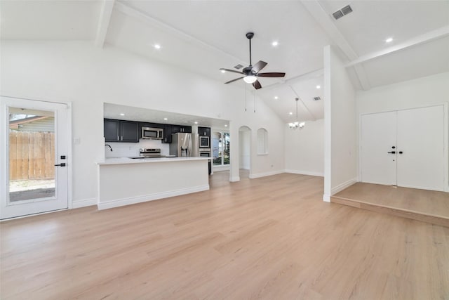 unfurnished living room featuring light wood finished floors, baseboards, visible vents, beamed ceiling, and ceiling fan with notable chandelier