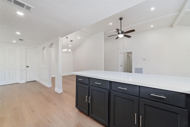 kitchen with light wood-type flooring, vaulted ceiling with beams, visible vents, and light countertops