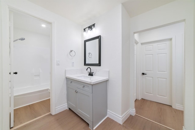 full bathroom with vanity, baseboards, and wood finished floors