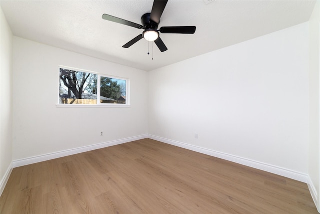 unfurnished room featuring baseboards, a ceiling fan, and light wood-style floors