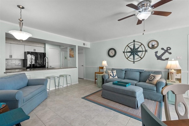 living room with light tile patterned flooring, a ceiling fan, and crown molding