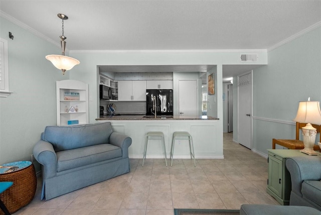 kitchen with visible vents, ornamental molding, open floor plan, white cabinetry, and black appliances