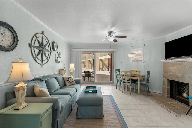 living area featuring ceiling fan, a textured ceiling, light tile patterned flooring, a fireplace, and crown molding