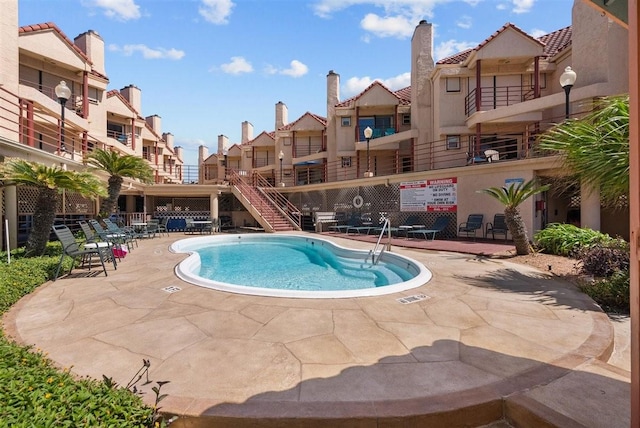 community pool featuring a residential view and a patio