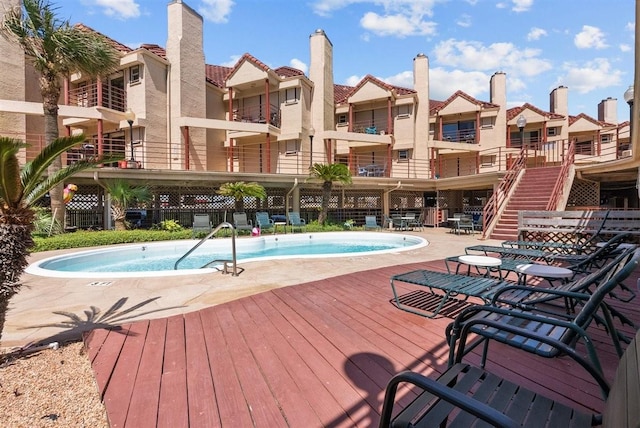 community pool featuring a patio area, a residential view, and fence