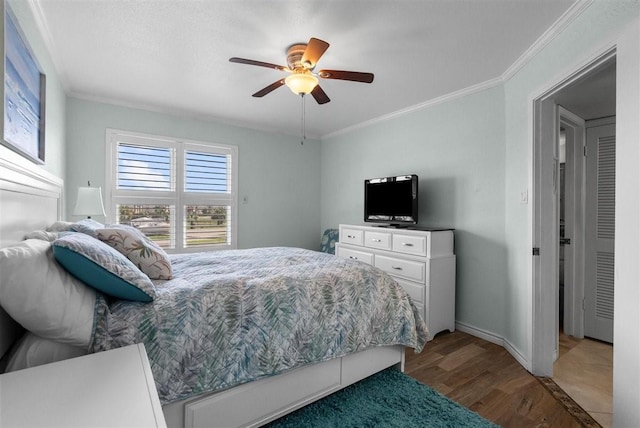 bedroom featuring a ceiling fan, crown molding, baseboards, and wood finished floors