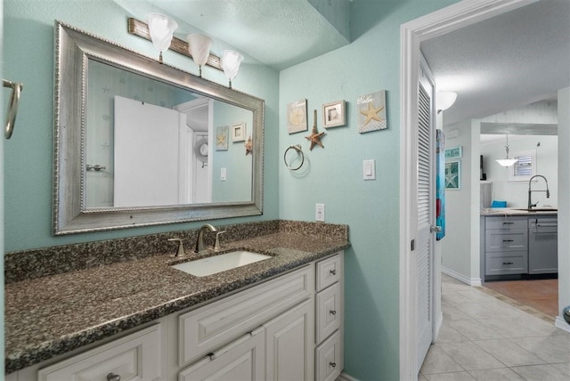 bathroom featuring a textured ceiling, tile patterned flooring, and vanity