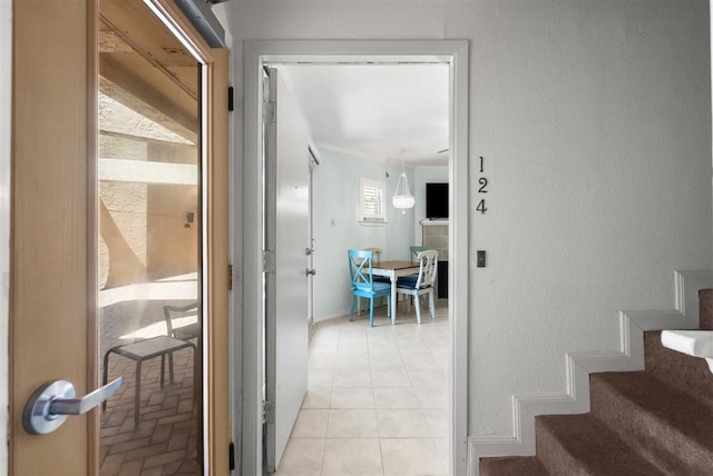 interior space featuring a textured wall, baseboards, and stairs