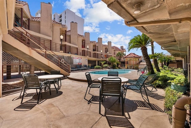 view of patio / terrace featuring a community pool and stairs