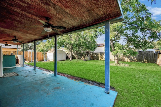 view of patio with an outbuilding, a shed, a fenced backyard, and a ceiling fan