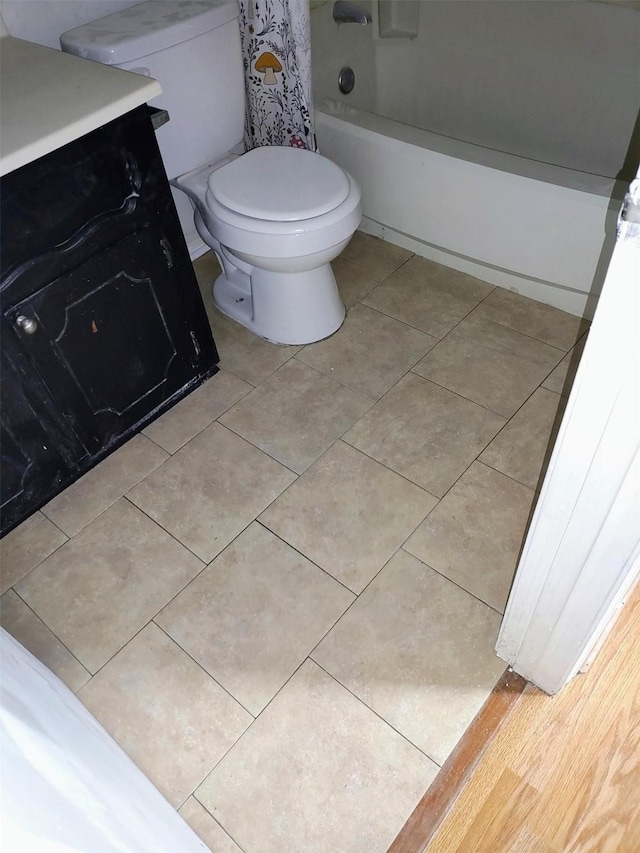 full bath featuring shower / bath combo with shower curtain, tile patterned flooring, and toilet