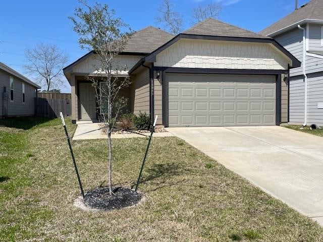 single story home featuring driveway, an attached garage, fence, and a front yard