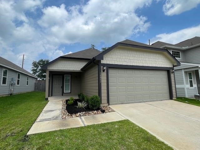 14041 Lamprey Dr, Conroe, TX 77384 - view of front of house featuring an attached garage, driveway, and a front yard