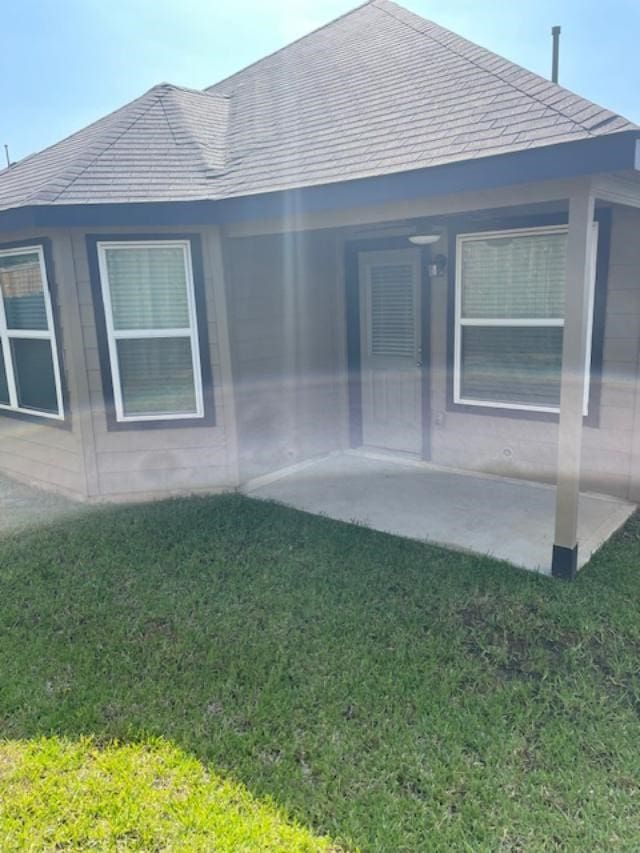 14041 Lamprey Dr, Conroe, TX 77384 - property entrance featuring a yard, a patio, and a shingled roof