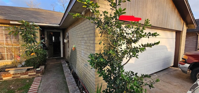 view of property exterior with a shingled roof, concrete driveway, and brick siding