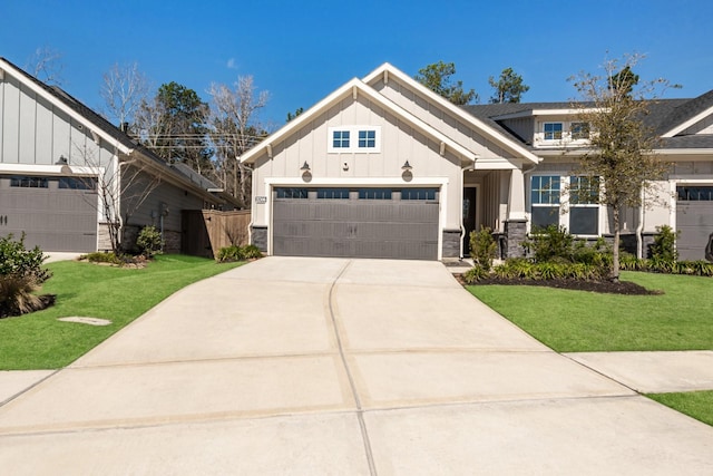 view of front of home featuring concrete driveway, board and batten siding, a garage, stone siding, and a front lawn