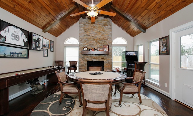 dining space with high vaulted ceiling, a stone fireplace, wood-type flooring, and a healthy amount of sunlight